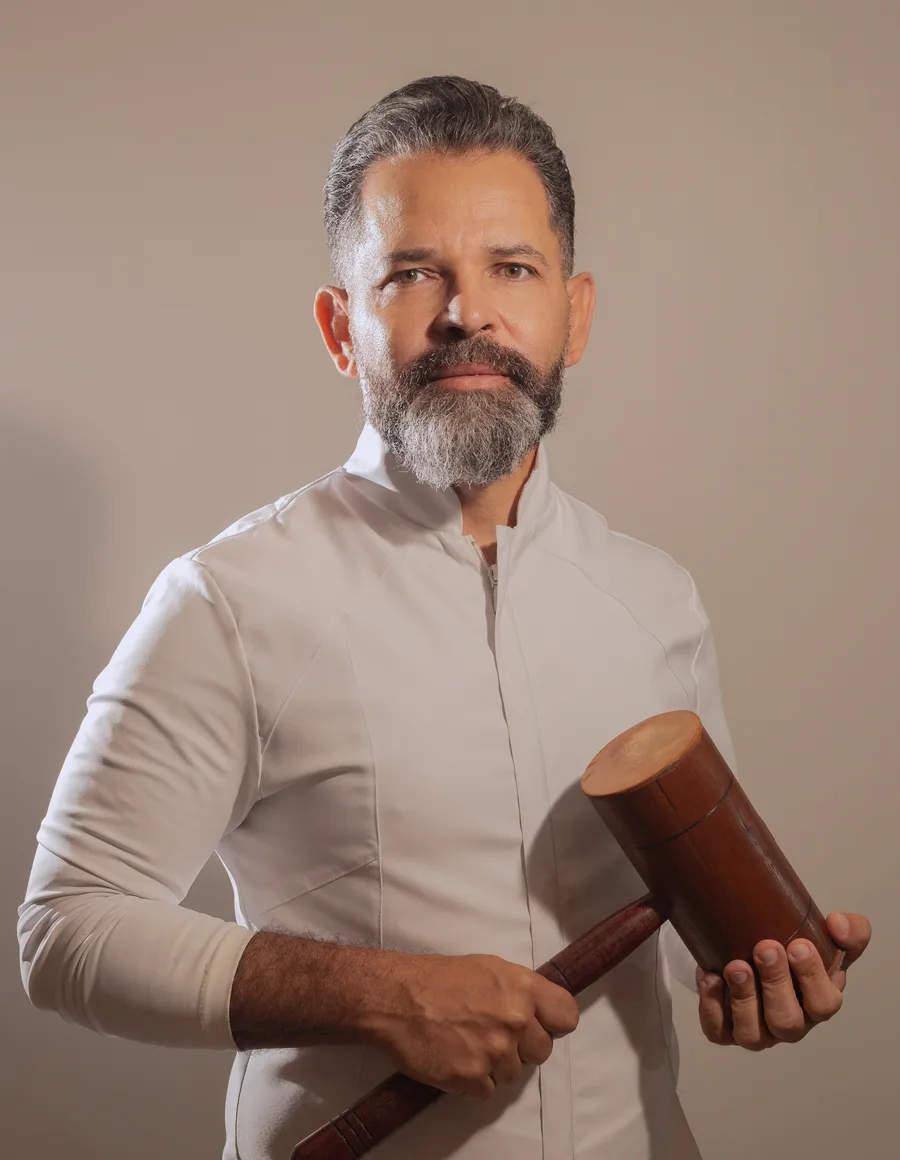 Fábio Pense segurando o martelo de madeira usado no New Seitai