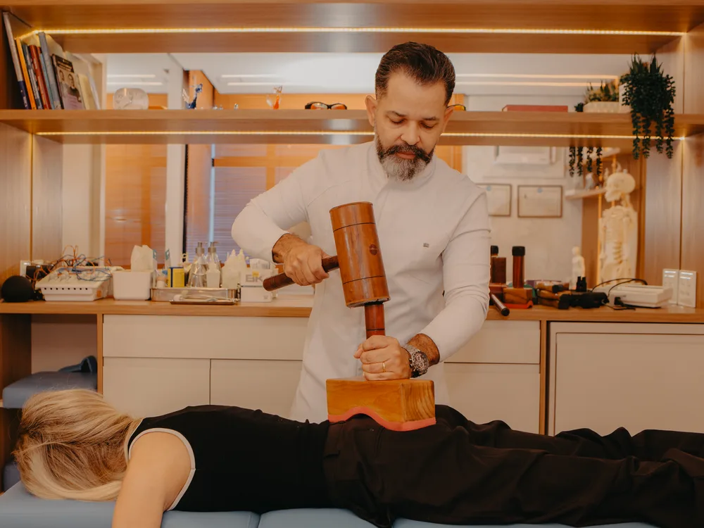Fábio Pense aplicando o New Seitai com o martelo de madeira na coluna